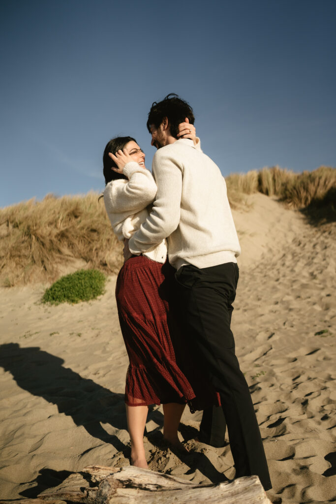 Couple hugging near rocky cliffs at golden hour