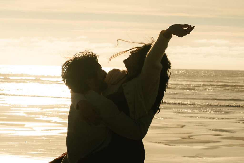 Man lifting his partner playfully at sunset