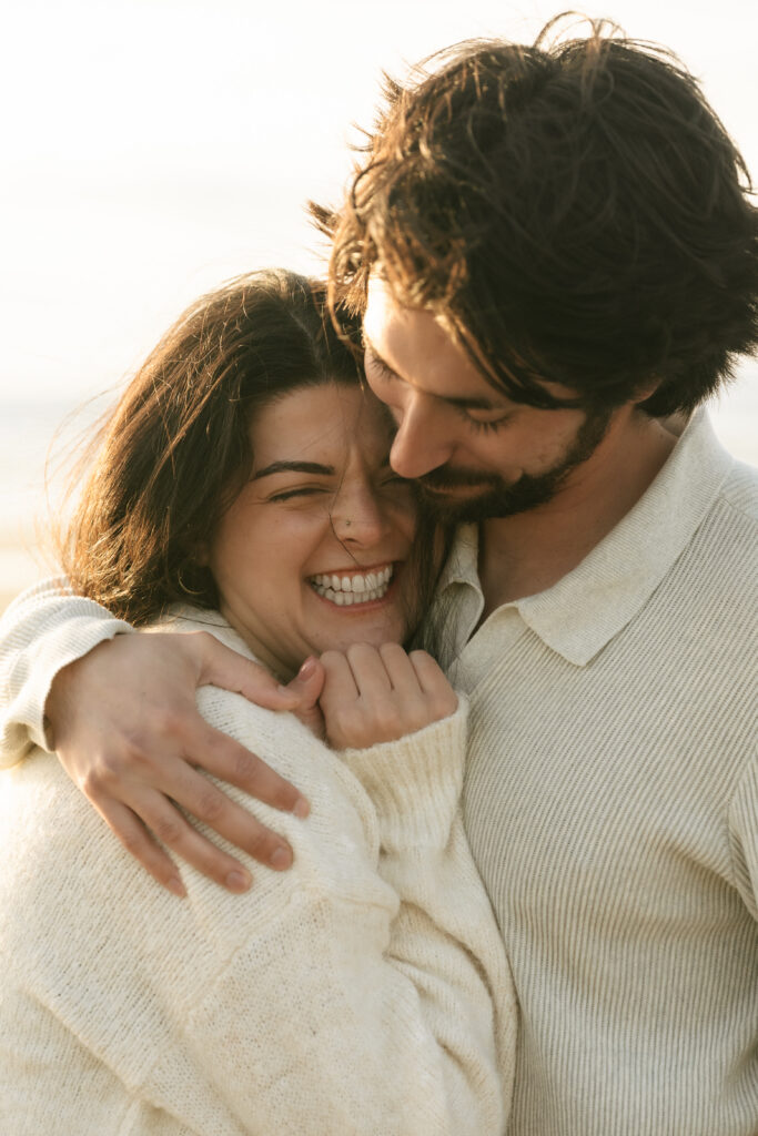 Couple standing together on the beach in soft golden light