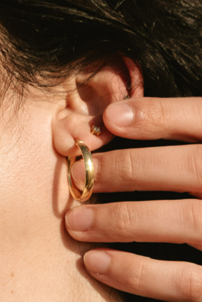 detail of mans fingers with a womans neck and earrings