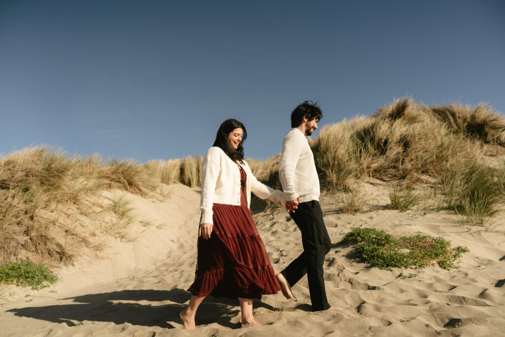Couple walking with ocean cliffs behind them
