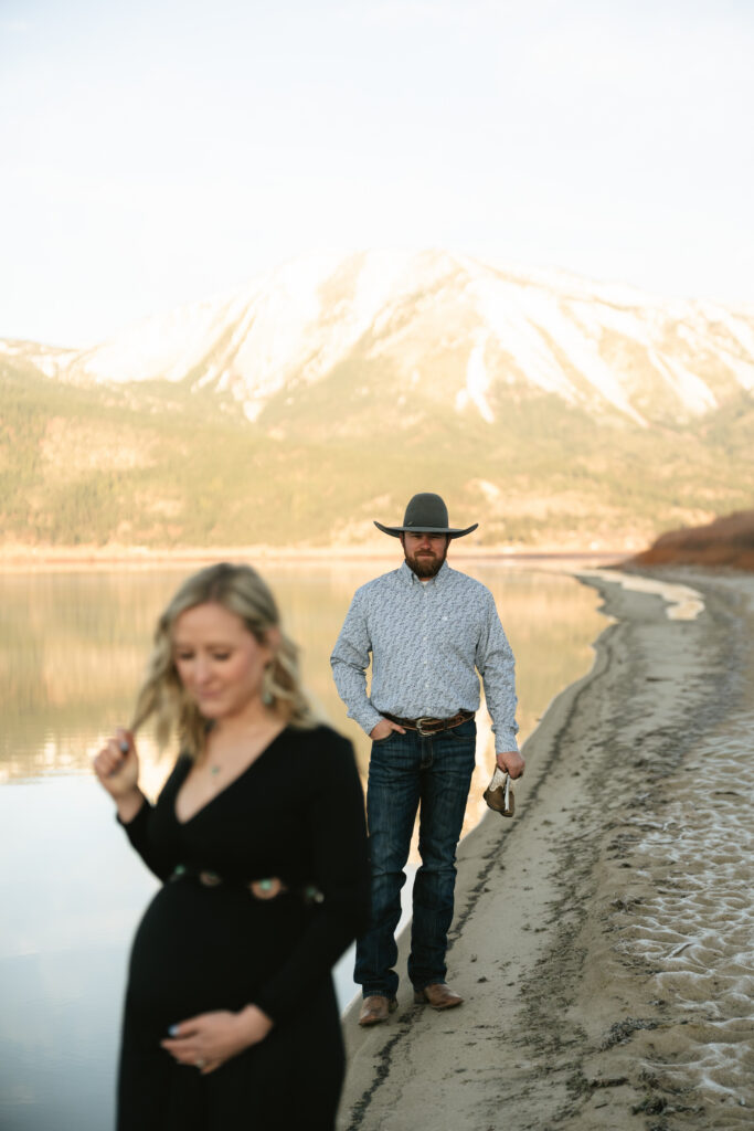 Film photo of man admiring pregnant woman walking alongside lake