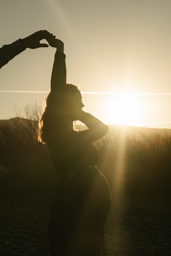 man spinning pregnat woman in sunlight