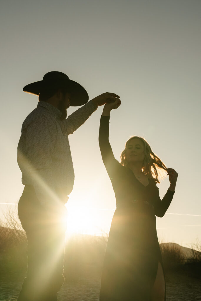 cowboy spinning pregnant woman in sunlight