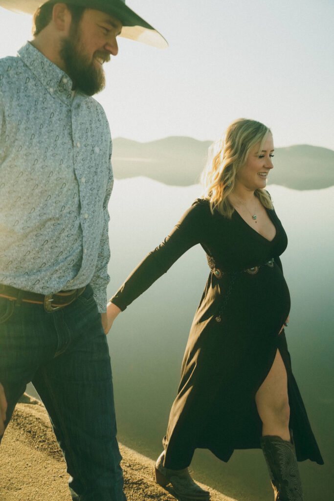 film photo of man and woman holding hands and walking next to a lake